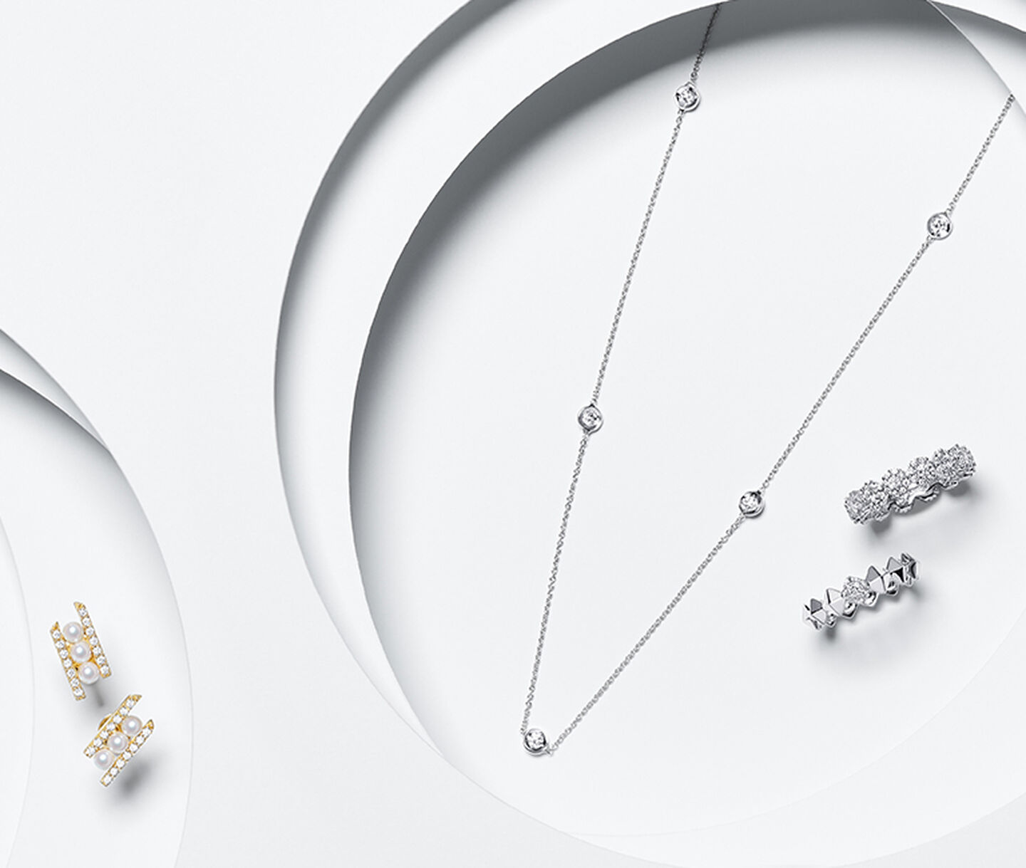 Diamond jewellery from Maison Birks on a white layered background.